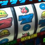 Imagen de una tragaperras mostrando tres sietes en línea, señal de un gran premio.